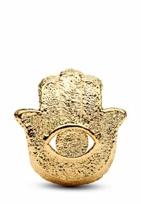 Talismano dorato a forma di mano con superficie testurizzata, caratterizzato da un motivo centrale a occhio. Il design è intricato, mettendo in risalto i dettagli decorativi.