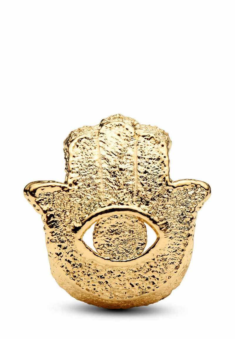 Talismano dorato a forma di mano con superficie testurizzata, caratterizzato da un motivo centrale a occhio. Il design è intricato, mettendo in risalto i dettagli decorativi.