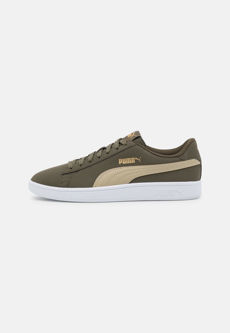 Chaussure de sport vert olive avec des accents beige, tige en matériau synthétique, semelle en caoutchouc blanche, et un logo Puma doré sur le côté.