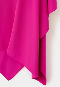 Tissu rose vif avec un ourlet asymétrique superposé, drapé sur un fond blanc.