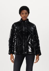 Black puffer jacket featuring a glossy, quilted design, high collar, zip closure, and side pockets. Texture appears smooth and shiny.