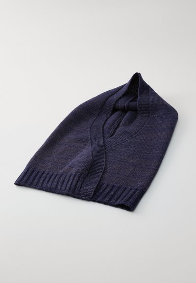 Tumši zila trikotāžas balaclava ar ribotām malām, salocīta plakanā stāvoklī uz gaiši pelēka fona.