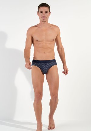 Herrenbrief in Marineblau mit einem gemusterten Design. Hergestellt aus weichem Stoff, mit einem kontrastierenden Bund und einer körpernahen Form.