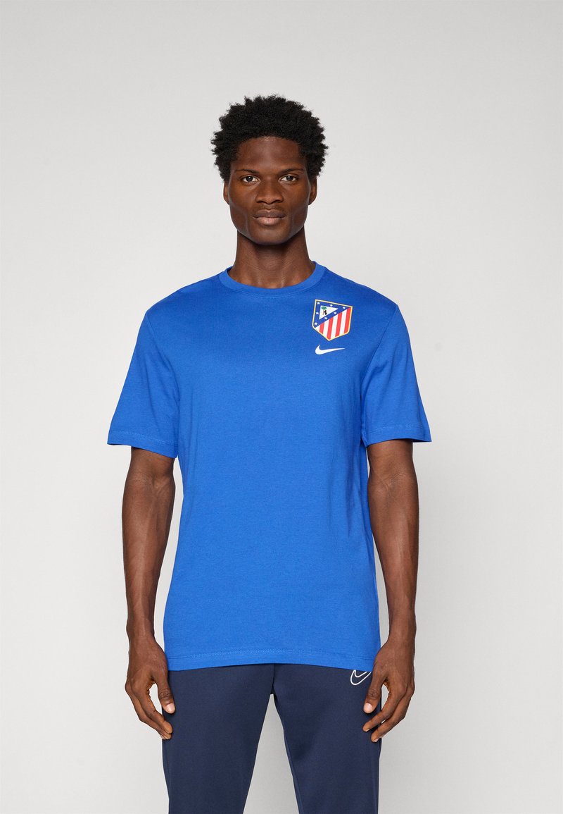 Blå Nike t-shirt med korte ærmer, med et logo og designdetalje på det øverste venstre brystområde. Materialet ser glat og letvægts ud.