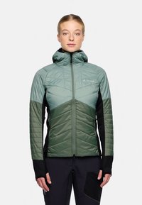 Lett isolert jakke med hette. Har to-tonet design i grønt og svart, quiltet tekstur, glidelås foran og tettsittende passform.