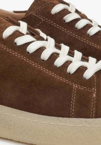 Brązowe zamszowe trampki z białymi sznurowadłami, textured surface, okrągłym noskiem i jasną gumową podeszwą. Szczegóły przeszycia wzdłuż boku.