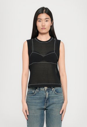Top negru fără mâneci cu o textură din plasă, cu cusături albe contrastante și un design ajustat. Asortat cu blugi din denim albastru.