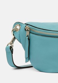 Borsa a tracolla in pelle turchese con chiusura a cerniera argentata, tracolla regolabile e dettaglio hardware circolare. Texture liscia, forma compatta.
