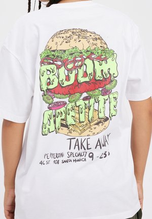 Persoon draagt een wit T-shirt met een kleurrijke burgerafbeelding en tekst met de woorden "Blood Appetite," "Take Away," en adresgegevens op de achterkant.