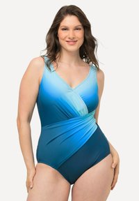 Bañador de una sola pieza en tonos azules degradados, con escote en V, diseño cruzado y tejido suave con un ligero brillo.