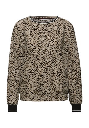 Blusa beige a maniche lunghe con motivo a macchie nere irregolari, polsini neri e scollatura rotonda con bordo bianco e nero.