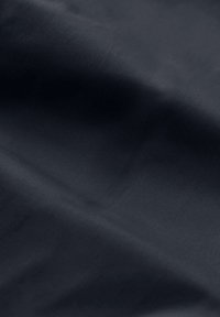 Un tessuto grigio scuro con una texture liscia e una leggera cordonatura. Il materiale appare leggero e resistente alle pieghe, senza motivi visibili.