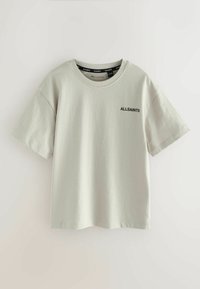 Světlá šedá krátká trička s krátkým rukávem vyrobená z měkké bavlny, s kulatým výstřihem a malým černým textovým logem na hrudi.