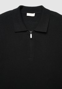 Schwarzes gestricktes Poloshirt mit einem Reißverschlusskragen und silbernem Reißverschlussanhänger. Waffelstruktur über das gesamte Shirt. Etikett lautet "CALLIOPE." Größe L.