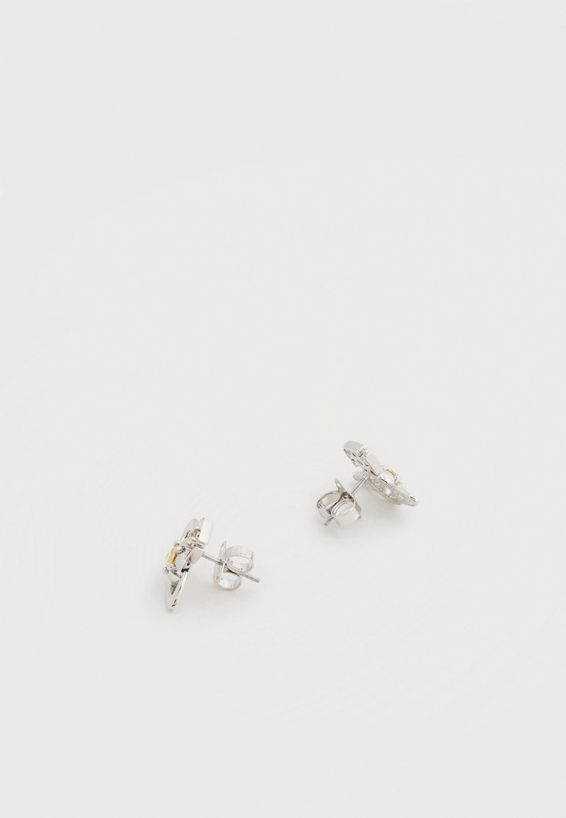 Silberne Ohrstecker mit rundem Design, einem kleinen gelben Edelstein in der Mitte, strukturierter Metalloberfläche und Schmetterlingsverschluss.