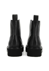Scarpe ankle in pelle nera con una superficie liscia, caratterizzate da una punta tondeggiante, una suola in gomma spessa e due linguette posteriori per indossarle facilmente.