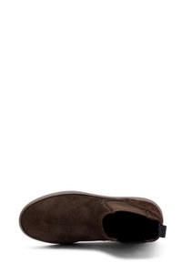 Botín de ante marrón con paneles laterales elásticos, punta redonda y superficie texturizada. Presenta una lengüeta en la parte trasera y una suela de goma.