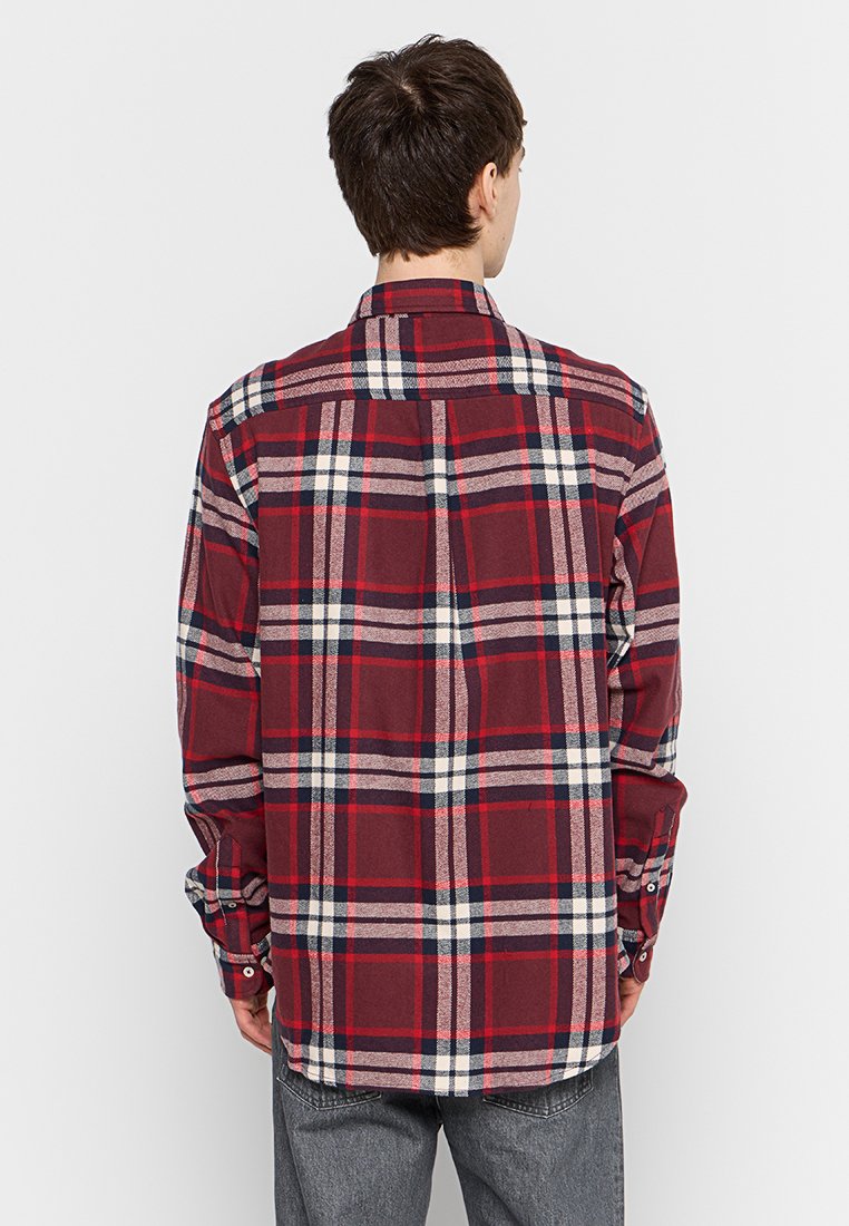 Camicia in flanella a quadri rossi con maniche lunghe e polsini abbottonati, caratterizzata da un motivo a scacchi bianco e blu navy, realizzata in tessuto morbido.