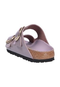 Sandal leggera rosa realizzata in materiale sintetico, con una soletta in sughero, due ampie cinghie con accenti color oro e una suola nera texturizzata.