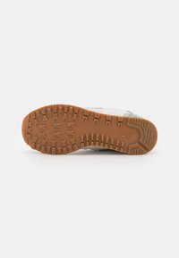 Treaded gum rubber outsole with a light gray upper and black accents. Textured surface with a thick profile for traction and durability.