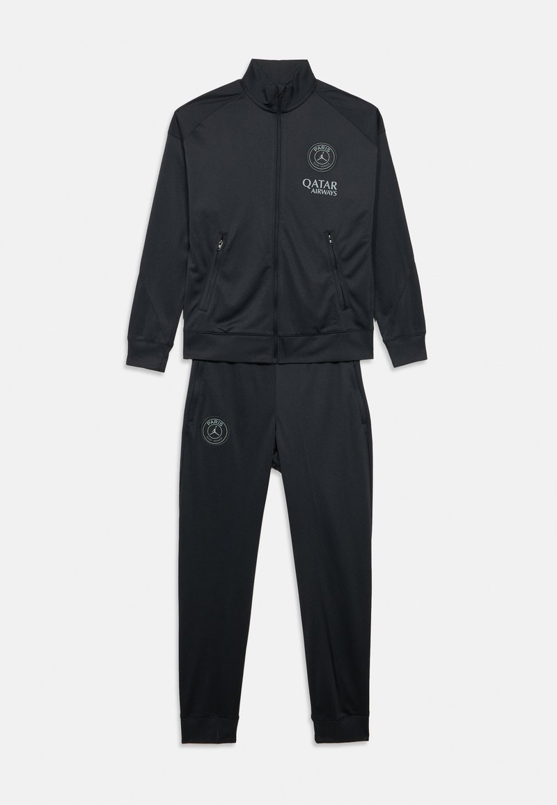 Chándal deportivo negro con chaqueta de cremallera con dos bolsillos laterales y pantalones con puños acanalados. Logotipos en el pecho y el muslo. Textura de tela suave.