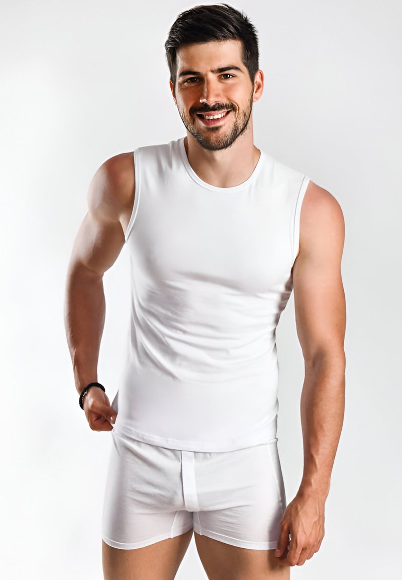 Chemise blanche sans manches en tissu lisse et élastique, associée à un boxer blanc ajusté, mettant en valeur une coupe slim et un design minimaliste.