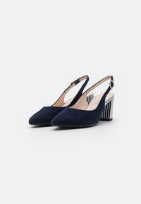 Tacchi slingback in suede blu navy con punta affusolata e tacco a blocchi rigati. Presentano una tracolla regolabile e una fodera interna liscia.