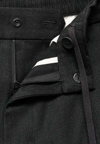 Pantaloni din denim negri cu închidere prin fermoar și nasture, talie elastică și accent alb cu dungi pe căptușeală. Material texturat.