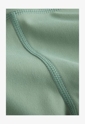 Grüner Stoff mit weicher Textur, ausgestattet mit einer flachen Naht und sauberem Abschluss, der sein leichtes und elastisches Design hervorhebt.