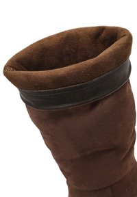 Bruine suède laars met een zwarte leren band aan de bovenkant. De binnenkant is zacht en de ontwerp is lang en aansluitend, met een taps toelopende onderkant.