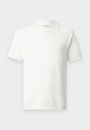 Witte polo met korte mouwen van gestructureerde stof en een kleine kraag, afgebeeld op een effen lichtgrijze achtergrond.