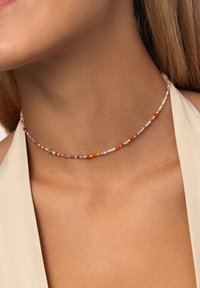 Collana choker di perline colorate caratterizzata da piccole perline rotonde nei colori arancione, rosa, viola e oro, disposte in un delicato schema.