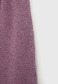 Violetti neulekangas näyttää tekstuuriltaan ribbikuosiselta, ja siinä on hieman löysä istuvuus sekä saumaton muotoilu reunoissa.