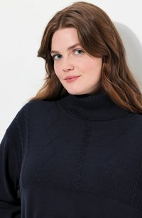 Laivastonsininen poolsweater, jossa on kaapelikudontamallit, ribbineck-kosketus ja timanttikuvio rinnan alueella. Pehmeä neulottu kangas.