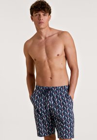 Marine zwemschoenen met een elastische tailleband en koord, met een wit en koraal flamingo-patroon door het geheel. Lichtgewicht stof.