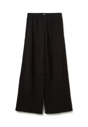 Pantalones de chándal anchos y negros, hechos de una tela suave. Cuentan con una cinturilla elástica y bolsillos laterales. Marca sutil cerca de la cinturilla.