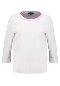 Blusa bianca a maniche lunghe con scollatura rotonda, caratterizzata da un bordo a contrasto in blu e rosso. Tessuto liscio con una vestibilità comoda.