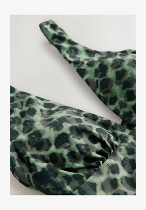 Közelről zöld és fekete leopárdmintás anyag, összegyűrt varrási részlettel a ruhadarab pántjain és kosaraion.