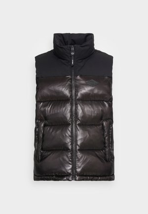 Gilet noir matelassé sans manches avec col montant, fermeture éclair frontale, poches latérales et texture matelassée brillante sur un fond uni.