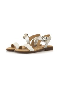 Sandalias blancas con una correa metálica texturizada y hebilla de gran tamaño. Presentan una banda frontal ancha y punta abierta. Suela texturizada de color marrón claro.