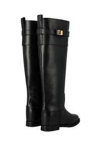 Bottes en cuir noir jusqu'au genou avec une finition lisse, dotées d'un accent en boucle dorée et de semelles plates pour la stabilité.