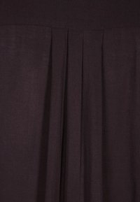 Tissu violet foncé avec des plis verticaux, d'une texture lisse et d'une finition mate, mettant en avant un design fluide et une douceur de tombé.