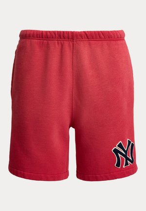 Red cotton shorts with elastic waistband and navy blue interlocking "NY" logo on the lower left leg.
