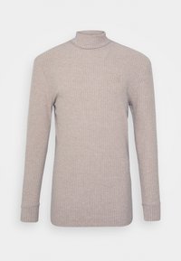 Maglione a collo alto beige a costine con maniche lunghe e design aderente. Presenta un piccolo logo ricamato sul petto. Tessuto morbido.
