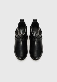 Des bottes noires en cuir à la cheville présentent une finition lisse, des orteils ronds, des accents de sangle ajustables et des fermetures éclairs latérales pour un enfilage facile.