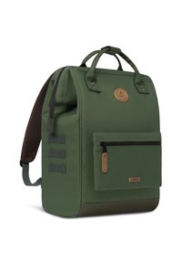 Groene rugzak met gevoerde schouderbanden, textielstof, handvatten aan de bovenkant, een voorvak met rits en een bruine leren logo-accent.