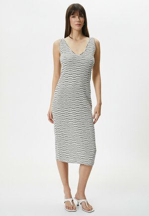 Hvid- og sortstribet bodycon kjole med V-hals, ærmeløs design og længde til midten af læggen, med et bølge mønster over hele kjolen.