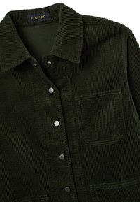 Giacca in velluto a coste verde scuro con colletto, bottoni a pressione in argento e tasca frontale. Tessuto texture con costole verticali.