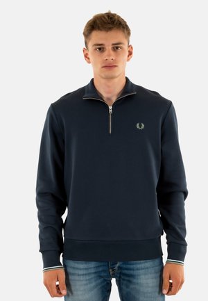Sweat-shirt navy à zip quart fabriqué en tissu doux, doté d'un petit logo brodé sur la poitrine et de poignets côtelés avec une touche rayée.