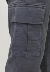 Marineblaue Cargo-Hose mit großer Seitentasche, abgesteppten Akzenten und einem glatten, strapazierfähigen Baumwollstoff mit leichtem Glanz.